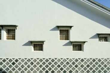 白壁の蔵造りの建物。壁には漆喰と海鼠（なまこ）壁の模様が見える。