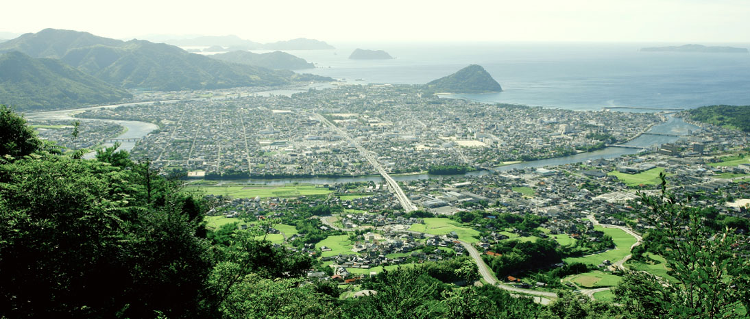 緑の自然が豊かな萩の町並みに、海へと続く川が流れている。