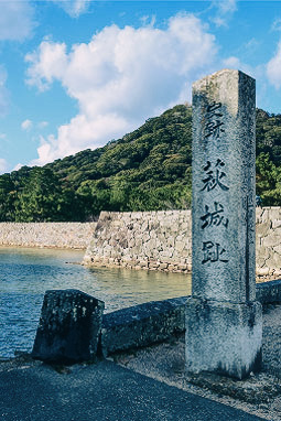 Stone monument inscribed with “Hagi Castle Ruins” and a view of mountains and stone walls that retain the appearance of the castle town