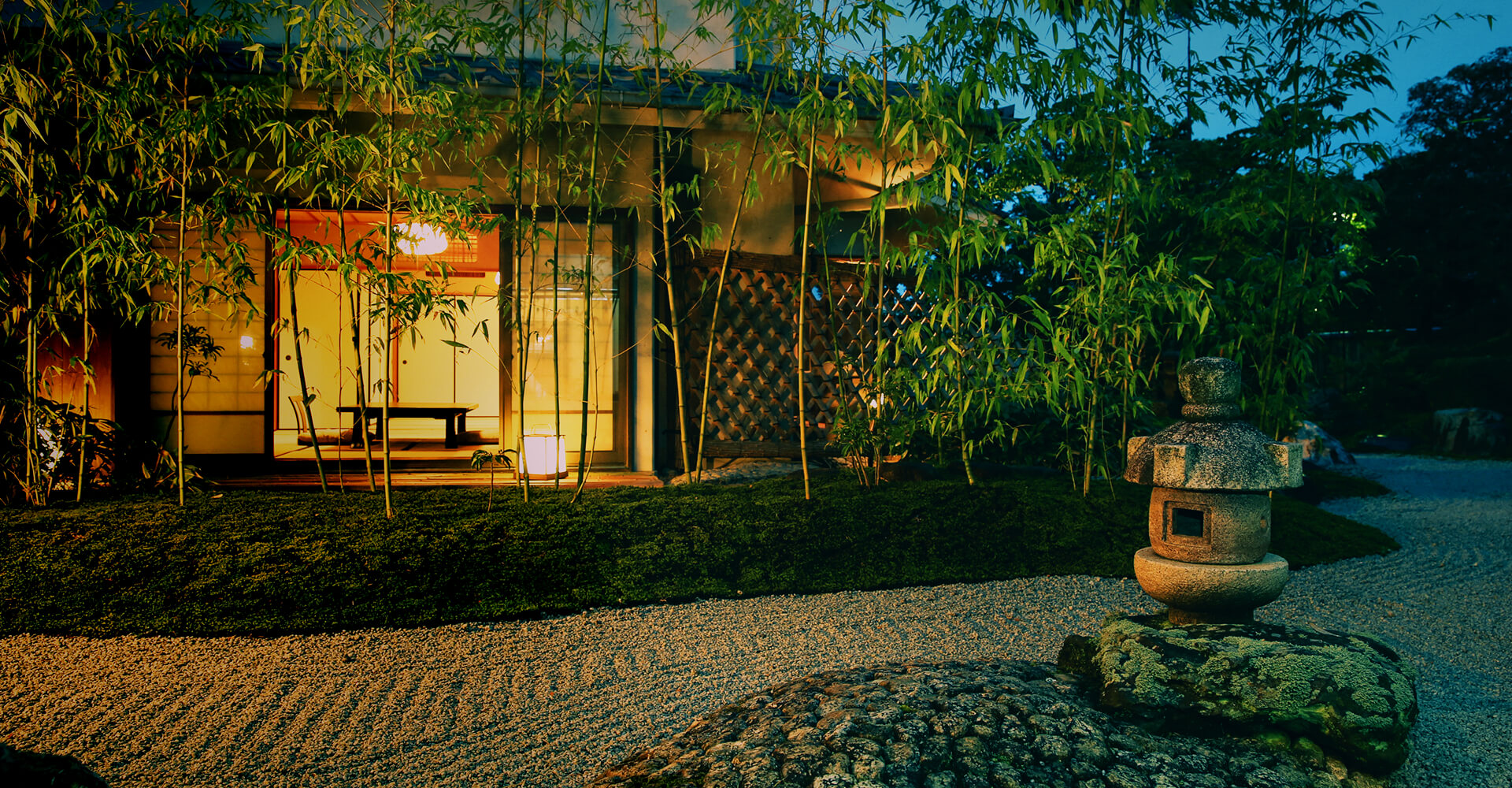 The Japanese-style building is lit, and bamboo and garden stones are beautifully arranged.