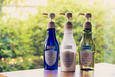 Bottle-type shampoo, body soap, and other bath amenities line the windowsill.
