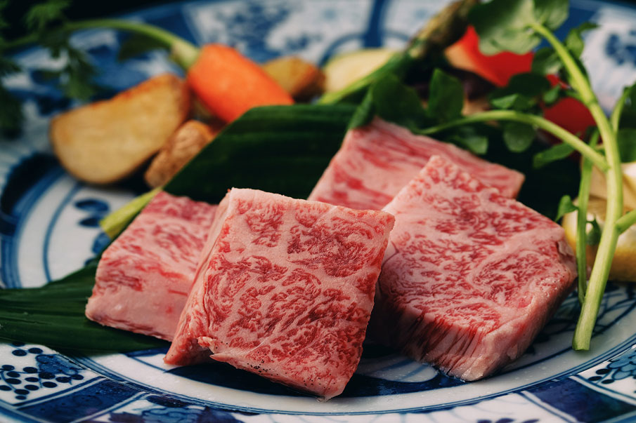 Marbled Wagyu beef steak served with colorful garnish.