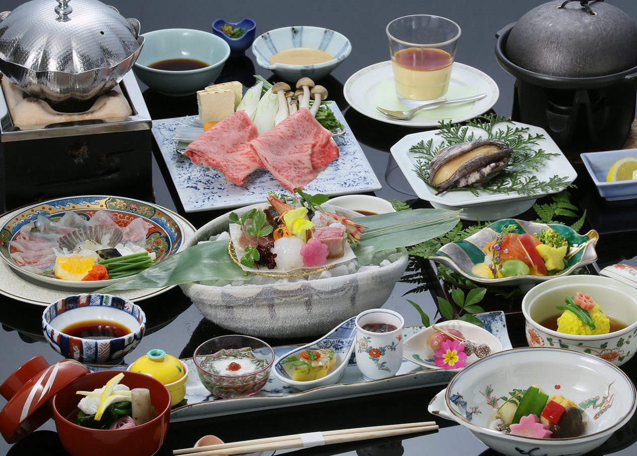 あわびやふぐ刺し、すき焼きなど様々な料理が並んだ会席料理