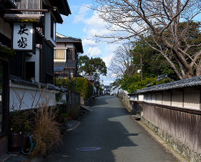 瓦屋根の町家が並ぶ、風情ある日本の伝統的な町並みを歩く細い路地